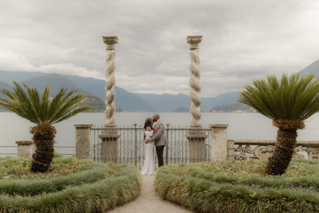 bride and groom kissing between the columns of Villa Monastero